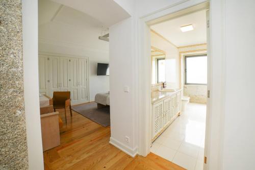 a living room with white walls and wooden floors at Solar das Bouças by Quantique in Amares