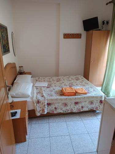 a bedroom with a bed with two towels on it at Anestis Apartments & rooms in Paleo Tsifliki