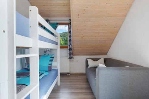 a room with a bunk bed and a couch at Ferienwohnung Sulzberg, 103qm in Alpirsbach