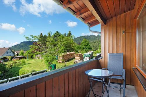 a balcony with a table and chairs and a view at Ferienwohnung Sulzberg, 103qm in Alpirsbach
