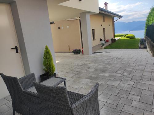 a patio with two chairs and a house at Luminoso appartamento vista lago in Solto Collina