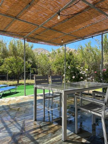 a table and two chairs under a wooden roof at Theros house in Livadion