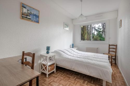 une chambre avec un lit, une table et une fenêtre dans l'établissement Appartement RDC pour 4 à 800m de la mer, à Pornic