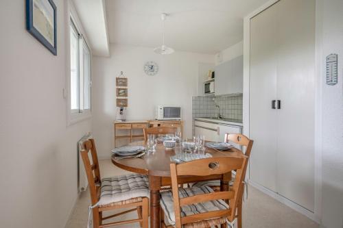 une cuisine et une salle à manger avec une table et des chaises dans l'établissement Appartement RDC pour 4 à 800m de la mer, à Pornic