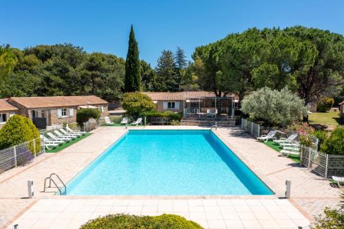 - une piscine dans une cour avec des chaises et des arbres dans l'établissement Charming T3 Bastidon in residence, à La Roque-sur-Pernes