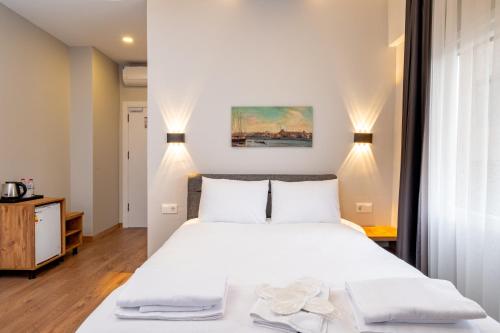 a bedroom with a large white bed and two lights at The Han YK Hotel in Avcılar