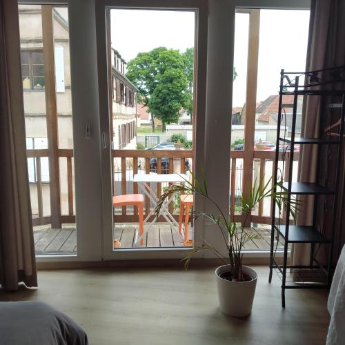 a bedroom with a door open to a balcony with a table at Nid de cigognes in Rosheim