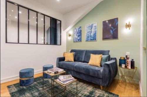 un salon avec un canapé bleu et une table dans l'établissement 3-cozy#1BR#Père-Lachaise#Nation, à Paris