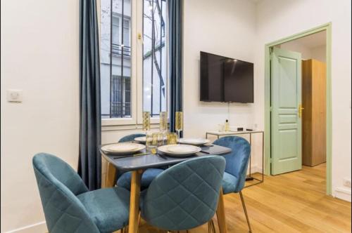une salle à manger avec une table et des chaises bleues dans l'établissement 3-cozy#1BR#Père-Lachaise#Nation, à Paris