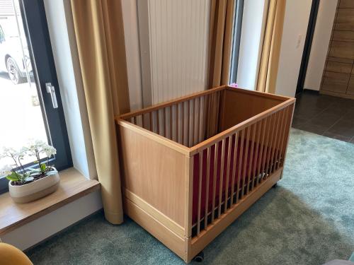 a crib in a room next to a window at PAULINEN Residenz in Detmold