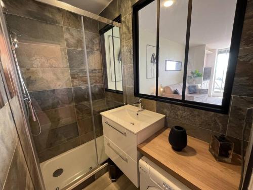 une salle de bain avec un lavabo, une douche et un miroir dans l'établissement Studio cabine CAP D'AGDE NATURISME CN060-AB124, au Cap d'Agde