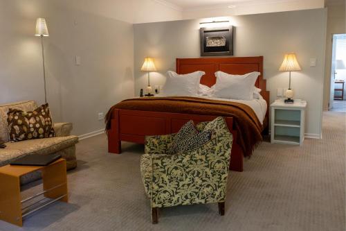 a hotel room with a bed and a chair at Schulphoek Seafront House in Hermanus