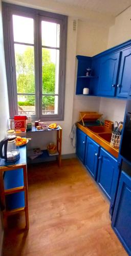 une cuisine bleue avec des placards bleus et une table dans l'établissement Appartement neuf proche Eurodisney Paris et RER E, à Pontault-Combault