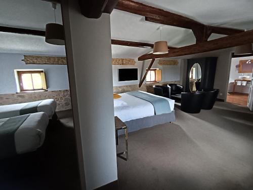 a bedroom with a bed and a living room at Logis Hôtel Château De Palaja in Carcassonne