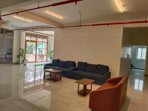a living room with couches and tables in a room at Auro Maison in Puducherry