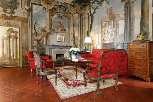 a living room with a red couch and a fireplace at Palazzo Niccolini al Duomo Residenza D'Epoca in Florence