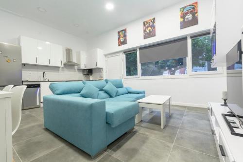 un salon avec un canapé bleu dans une cuisine dans l'établissement Laredo Suite 1, à Laredo