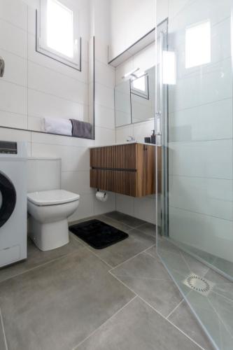 une salle de bain avec toilettes et douche en verre dans l'établissement Laredo Suite 1, à Laredo