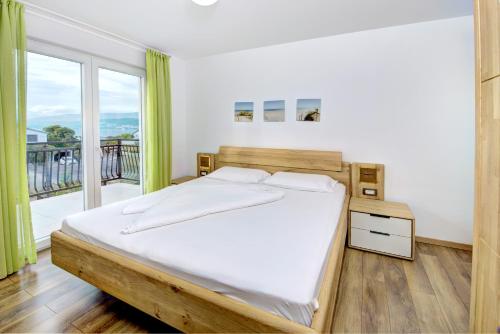 a bedroom with a bed and a large window at Cool Šilo Appartement Resort in Šilo