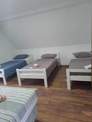 three beds in a room with wooden floors at Kuća za odmor Noah in Bihać