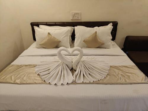 two swans are forming a heart on a bed at Ekantam Aspen By Yatri India Hospitality in Rishīkesh