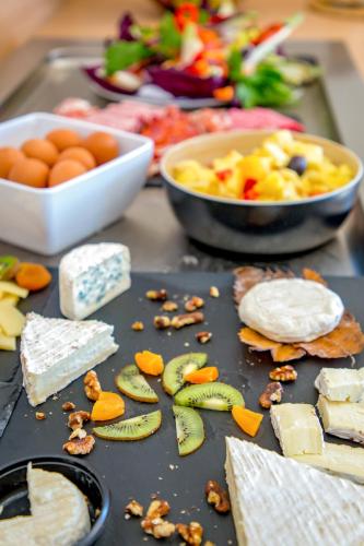 a table topped with different types of cheese and other foods at Best Western Plus La Marina in Saint-Raphaël