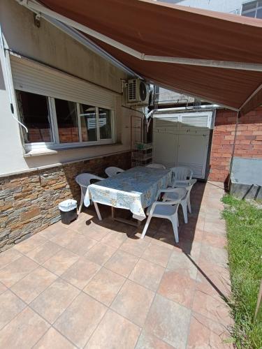 a patio with a table and chairs and an umbrella at Albergue Ultreia Sigueiro in Sigüeiro