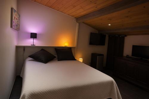 - une chambre avec un lit blanc et une lumière violette dans l'établissement INSOLITE STUDIO -La Tour des Templiers-, à Montfrin