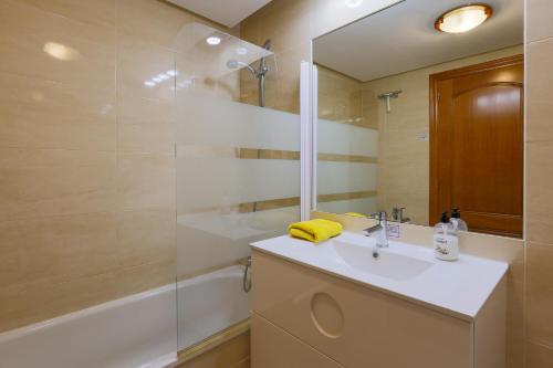 Un baño con lavabo, ducha y espejo. en Beach Huisje Mar Menor, en Mar de Cristal