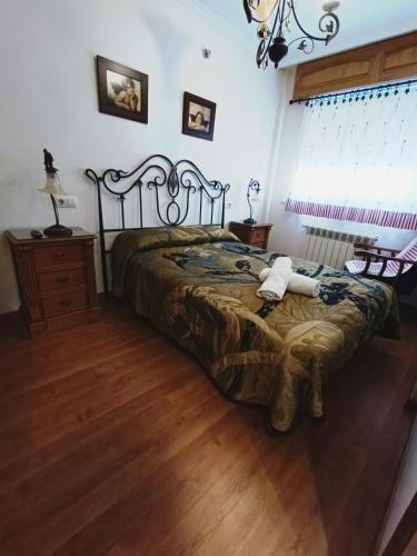 a bedroom with a bed and a dresser and a window at Albergue Ultreia Sigueiro in Sigüeiro