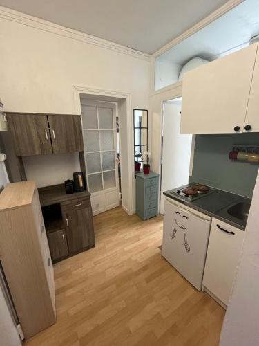 une cuisine avec des appareils électroménagers blancs et du parquet dans l'établissement Nice 2 Rooms Full Appartement in Paris, à Paris