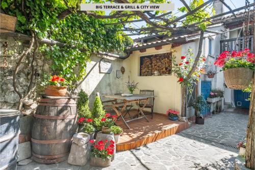 a patio with a table and a bunch of flowers at Apartma Hiša Pliska in Pliskovica