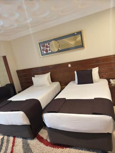 two beds sitting next to each other in a room at Airport West Hotel in Accra