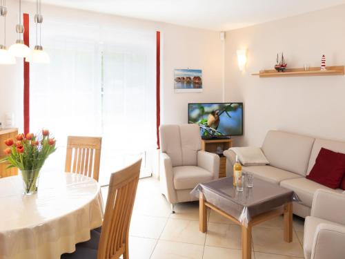 a living room with a table and a couch at Holiday Home Heide by Interhome in Ostseebad Karlshagen