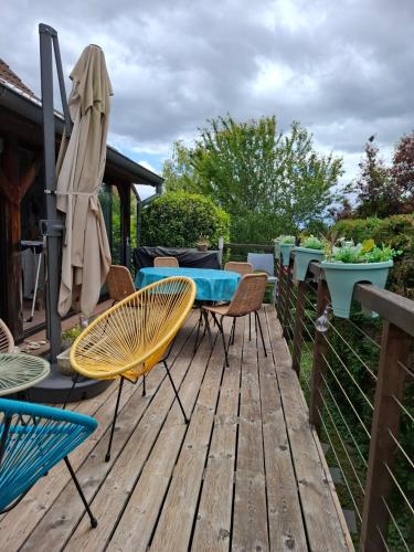 une terrasse en bois avec des chaises, une table et des chaises dans l'établissement maison spa sauna wattwiller, à Wattwiller
