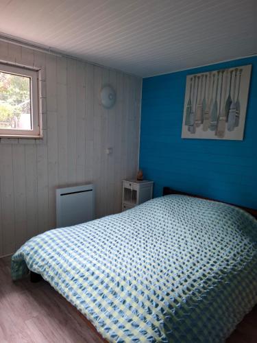 une chambre avec un lit avec un mur bleu dans l'établissement maison spa sauna wattwiller, à Wattwiller