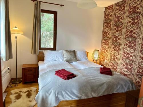 a bedroom with a bed with two red towels on it at Alpine View Villa in Razlog