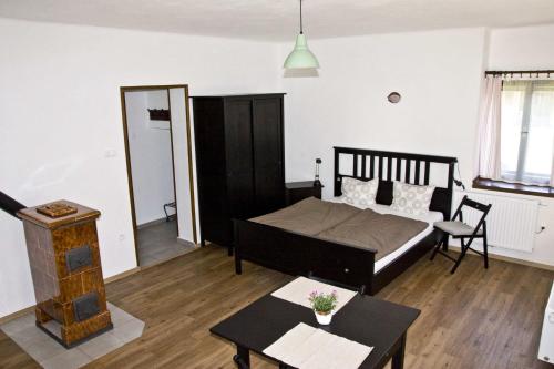 a bedroom with a bed and a living room at Penzion Albeř in Nová Bystřice