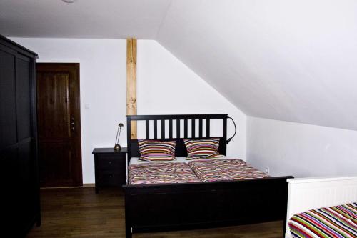 a bedroom with a black bed with striped pillows at Penzion Albeř in Nová Bystřice