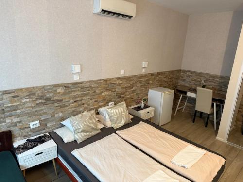 a bedroom with a bed and a brick wall at Mosoly Szallashely in Szeged