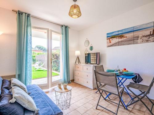 un salon avec un canapé bleu et une table dans l'établissement Apartment Les Jardins de la Nartelle Plage by Interhome, à Sainte-Maxime
