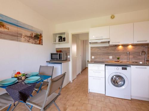 une cuisine et une salle à manger avec une table et un lave-linge dans l'établissement Apartment Les Jardins de la Nartelle Plage by Interhome, à Sainte-Maxime