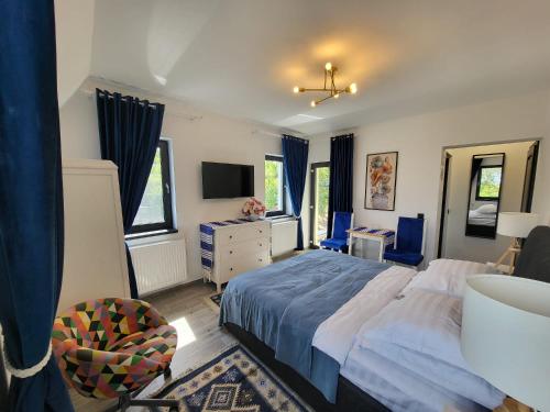 a bedroom with a bed and a desk and a tv at Pensiunea Casa Dacilor in Podeni