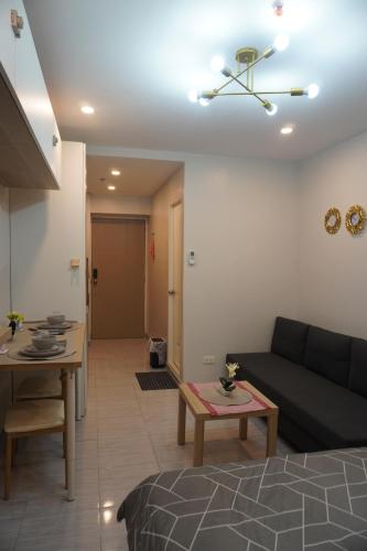a living room with a black couch and a table at Quezon City Apartment 2 Condo-Hotel with Pool View in Manila