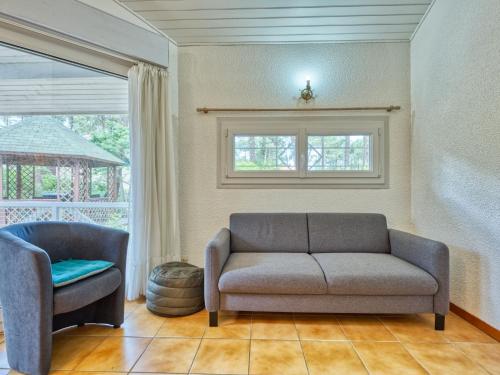 un salon avec un canapé et une chaise dans l'établissement Holiday Home Golf Loisirs-1 by Interhome, à Lacanau-Océan