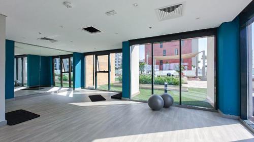 an empty room with large windows and a gym at Chic and comfortable Studio Near Downtown and Canal in Dubai