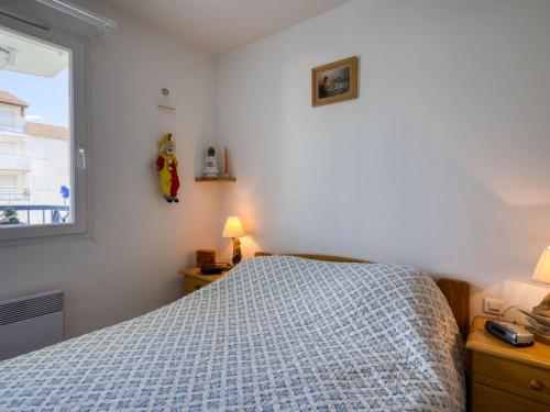 a bedroom with a bed with a blue blanket and a window at Apartment Terrasses de Pontaillac by Interhome in Pontaillac