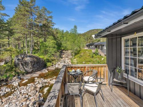 eine Terrasse mit einem Tisch und Stühlen auf einem Haus in der Unterkunft Chalet Sandrabu by Interhome in Øyuvstad