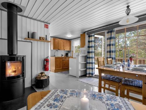 eine Küche mit einem Tisch und einem Herd im Zimmer in der Unterkunft Chalet Sandrabu by Interhome in Øyuvstad