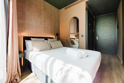 a bedroom with a large white bed with towels on it at Hotel Arena Select in Valencia